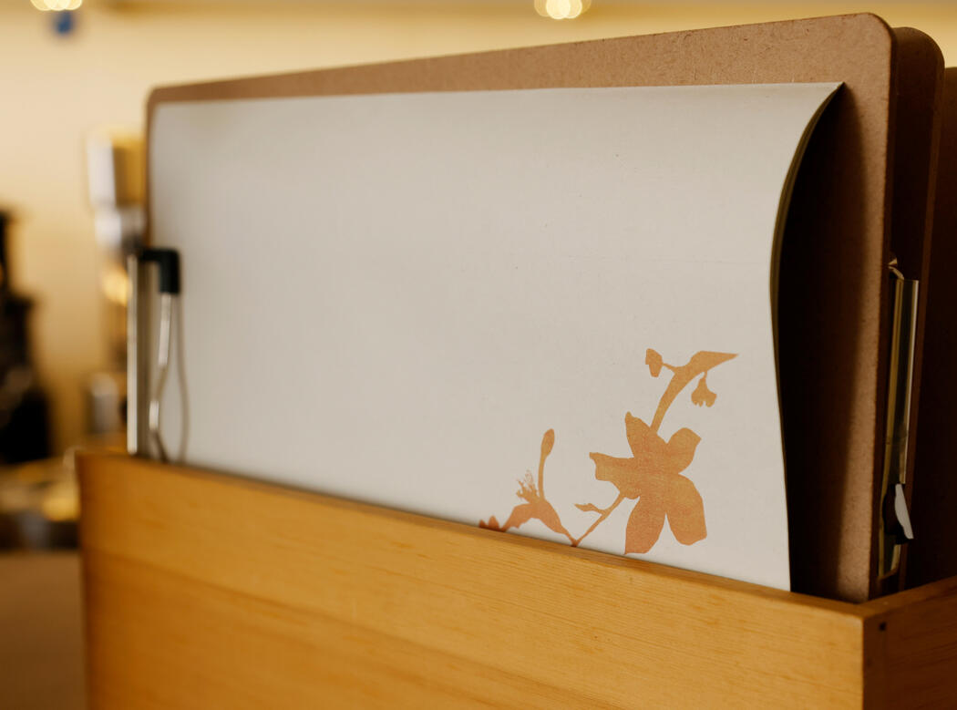 Veggieterraneo paper menus featuring the floral motif from the restaurant's identity